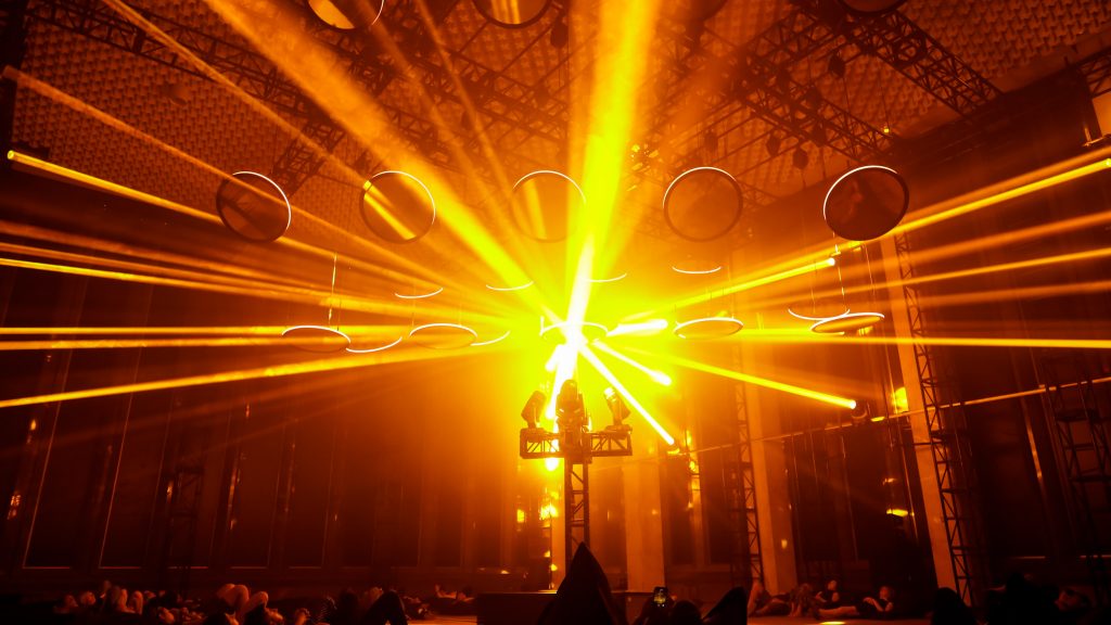 Attendees lay on the ground and watch the SKALAR art installation light show in Detroit.