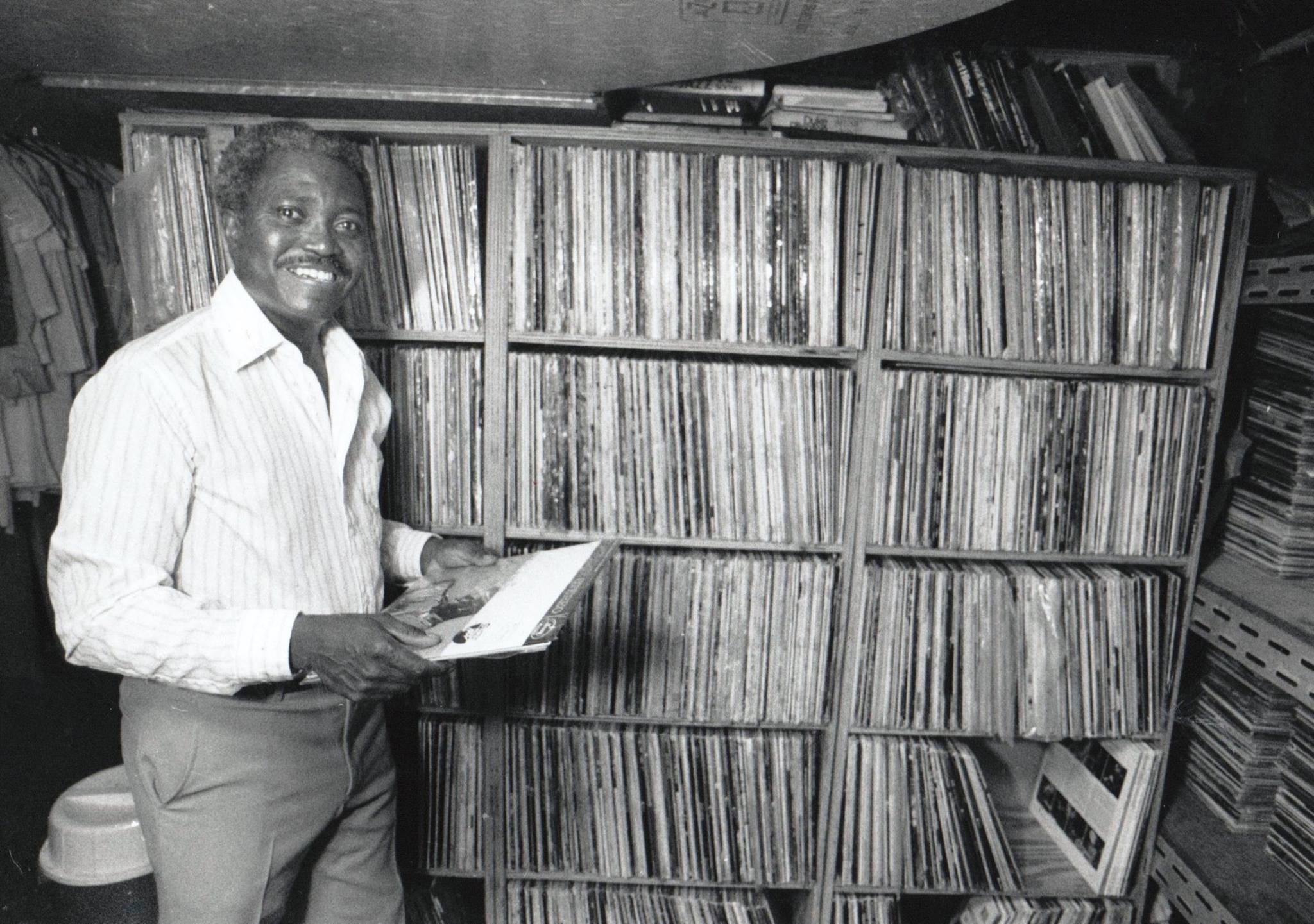 Ed Love smiles in front of WDET's music library