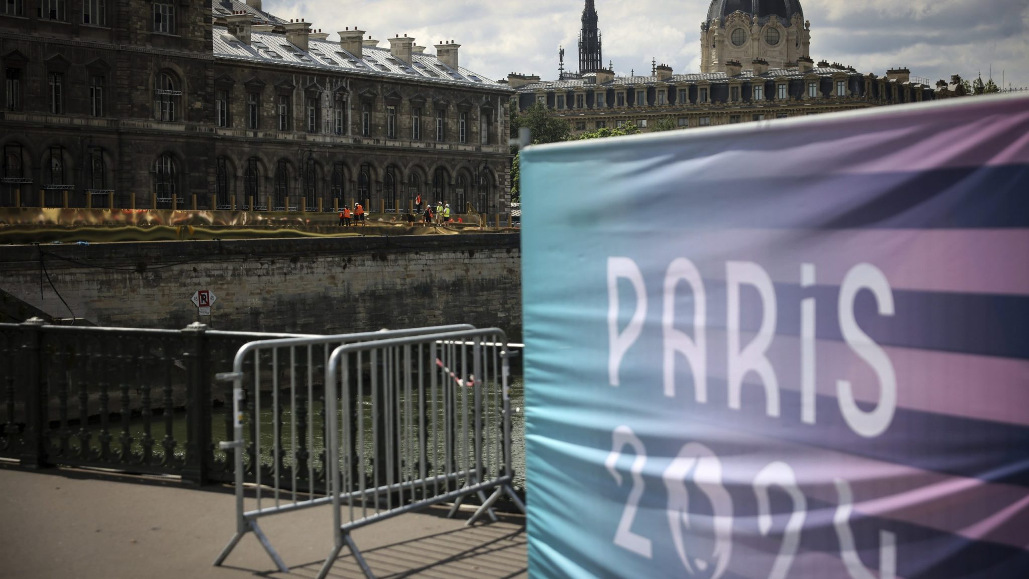 Workers operate along the Seine river at the 2024 Summer Olympics, Sunday, July 21, 2024, in Paris, France.