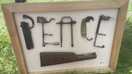 Pieces of chopped up guns arranged to spell "Peace."