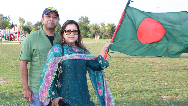 Two people holding up a Bangladeshi national flag.