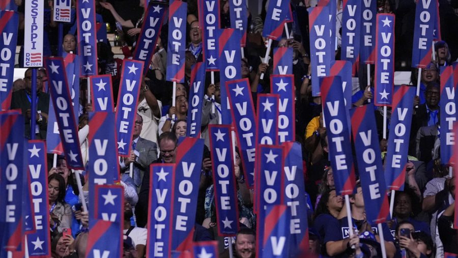 Delegates hold signs as former President Barack Obama speaks during the Democratic National Convention Tuesday, Aug. 20, 2024, in Chicago.