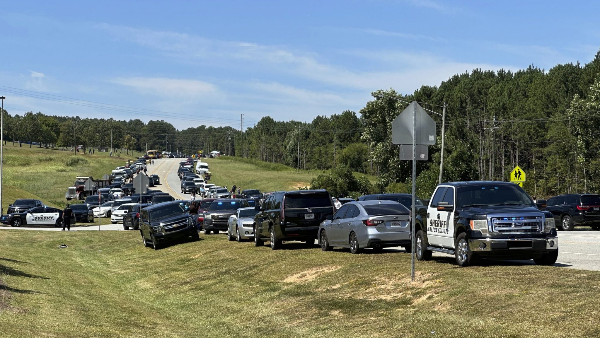 Law enforcement arrive as students are evacuated to the football stadium after the school campus was placed on lockdown at Apalachee High School in Winder, Ga., on Wednesday, Sept. 4, 2024.