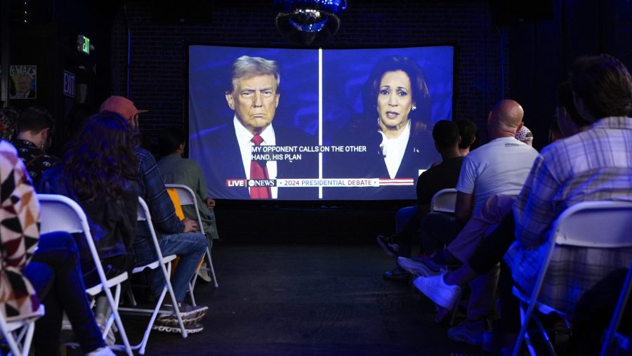 Republican presidential nominee former President Donald Trump and Democratic presidential nominee Vice President Kamala Harris are seen on a projector during a watch party at Massive, a queer nightclub, Tuesday, Sept. 10, 2024, in Seattle.