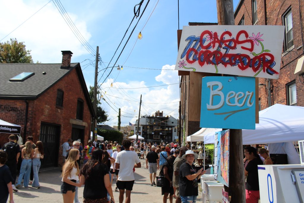 A sign reads "Midtown" with "Cass Corridor" spray-painted over it