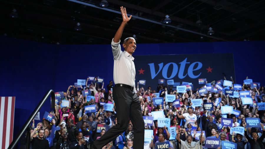 Barack Obama walks onstage and waves to a crowd in Detroit