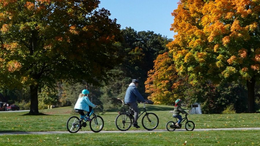 A family riding bikes at an Oakland County park in fall.