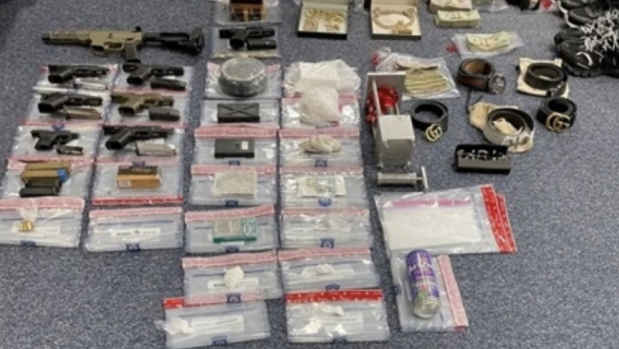 Guns, drugs, cash and jewelry seized by law enforcement.