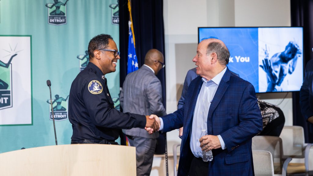 Detroit Police Chief Todd Bettison and Mayor Mike Duggan shake hands at a press conference.