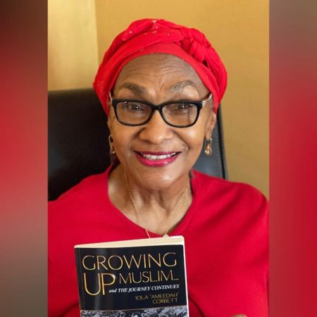 Iola Corbett holds up a copy of her book, "Growing Up Muslim"