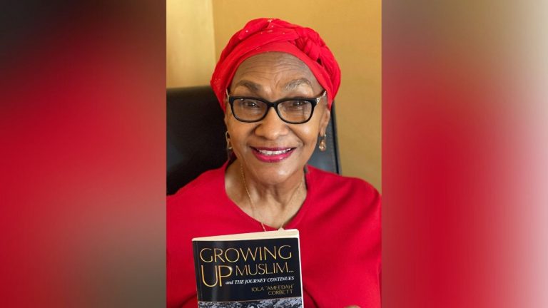 Iola Corbett holds up a copy of her book, "Growing Up Muslim"