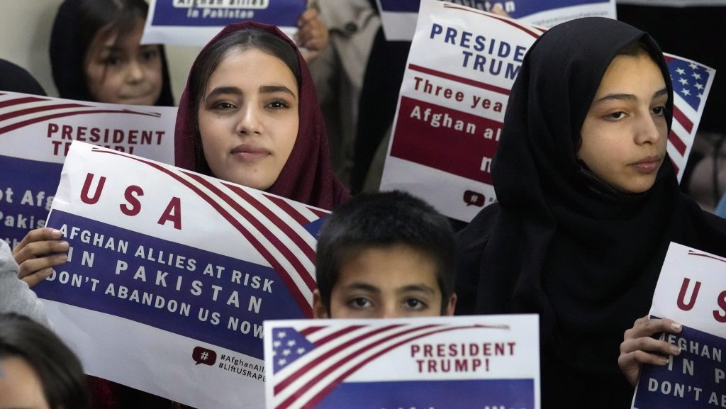 Afghan refugees hold placards during a meeting to discuss their situation after President Donald Trump paused U.S. refugee programs, in Islamabad, Pakistan, Friday, Jan. 24, 2025.