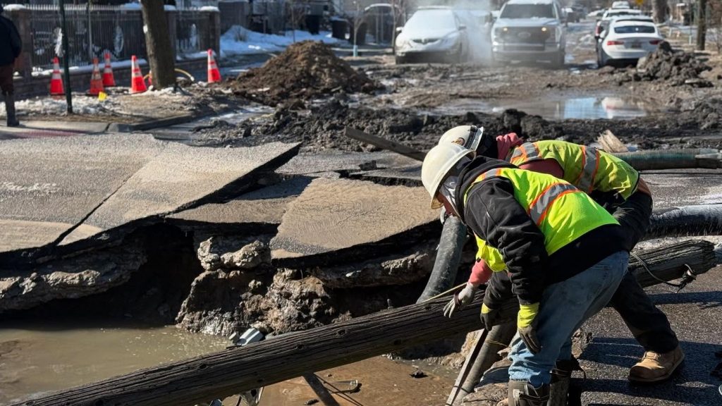 A flood response team works to drain a street