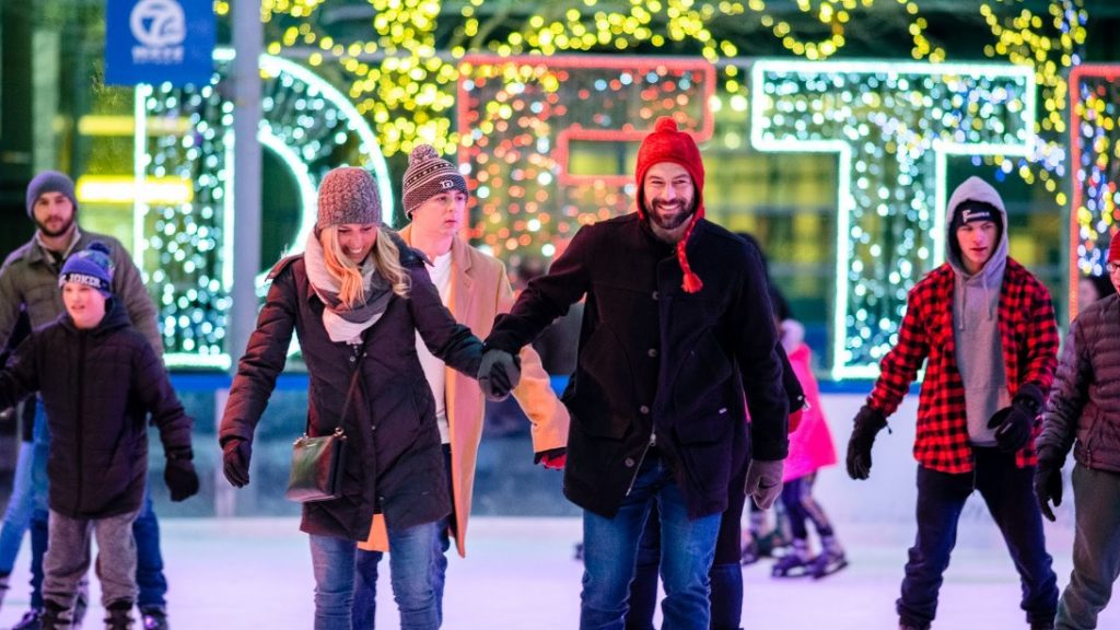 A couple holds hands while ice skating