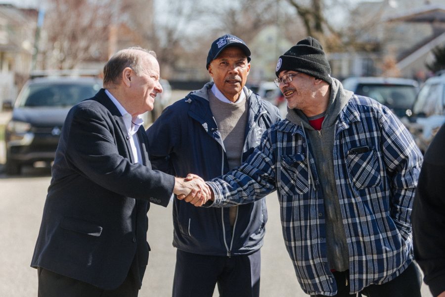 Mike Duggan shakes hands with a resident at a press conference in Southwest Detroit