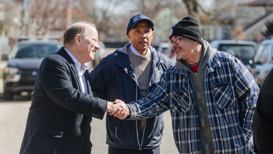 Detroit Mayor Mike Duggan shakes hands with a resident at a press conference in Southwest Detroit.