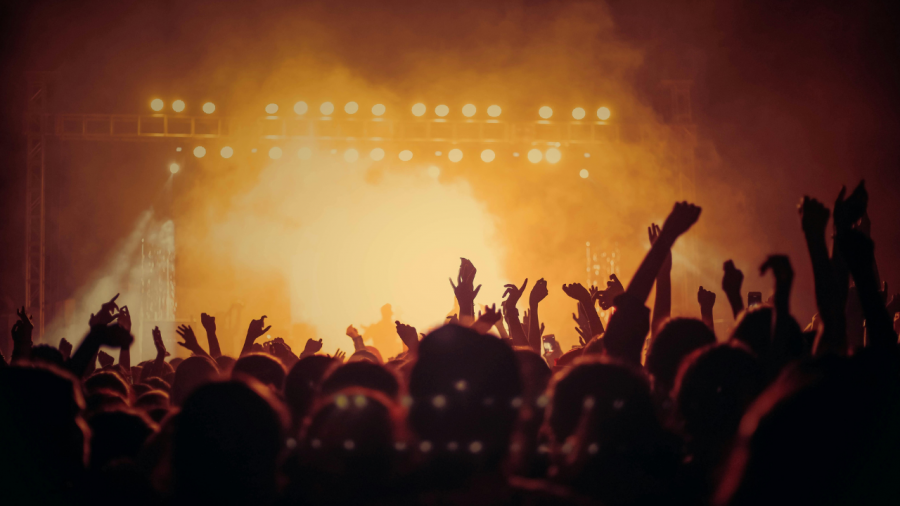 Crowd at a concert backlit.