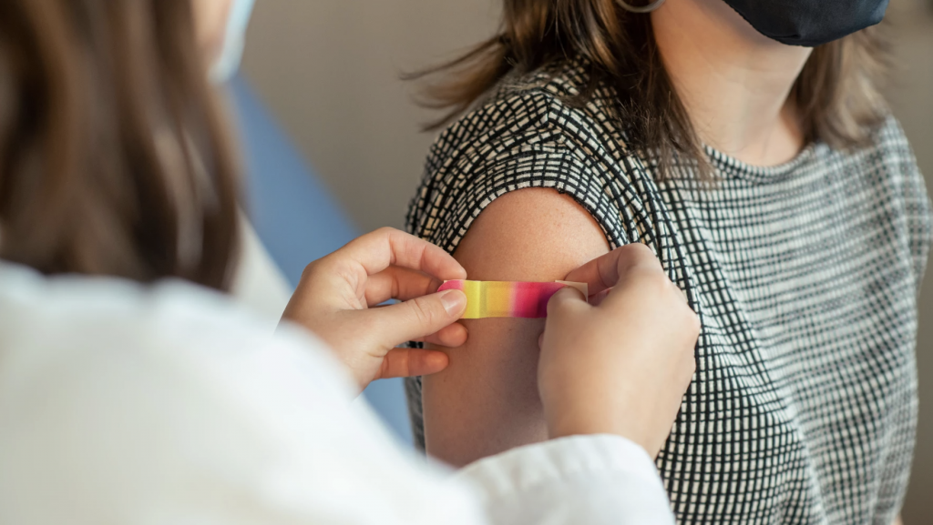A patient gets a bandage after receiving a vaccine for influenza.