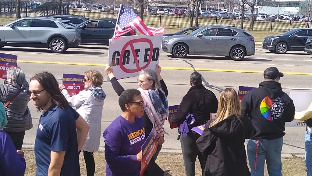About 100 unionized health care workers and others who depend on Medicaid demonstrated outside Michigan Republican Congressman John James' office in Warren on Wednesday, March 19, 2025.