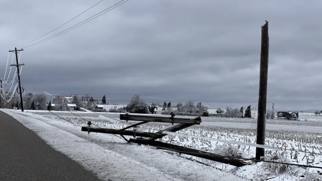 A snapped off utility pole lays by the side of the road in Bear Creek Township, Michigan.