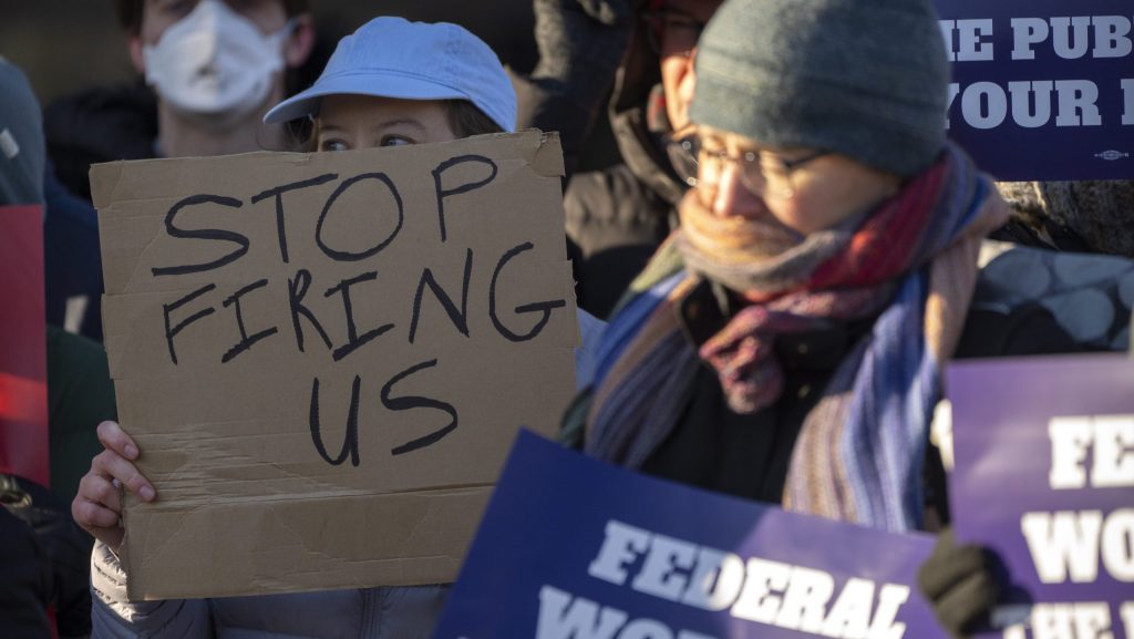 FILE - Demonstrators rally in support of federal workers outside of the Department of Health and Human Services, Feb. 14, 2025, in Washington.