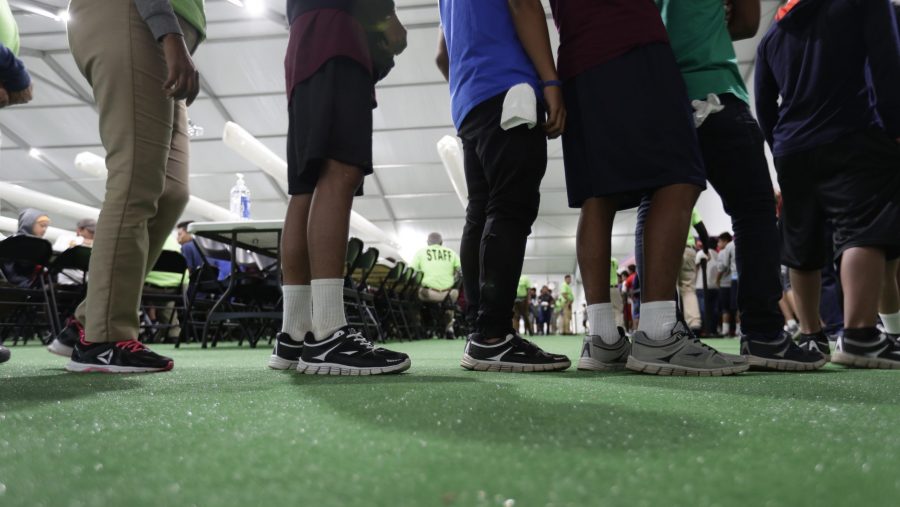 FILE - Immigrants line up in the dining hall at a U.S. government holding center for migrant children, July 9, 2019, in Carrizo Springs, Texas.