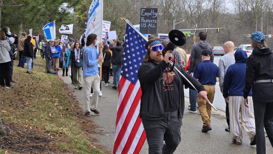 Army veteran Justin Coates marches with protestors in Ann Arbor on Saturday, March 30, 2025.
