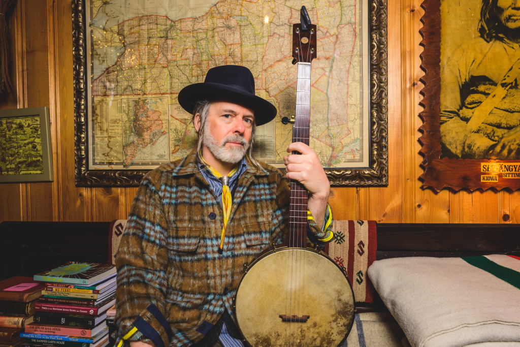 Ethan Daniel Davidson poses holding a banjo.
