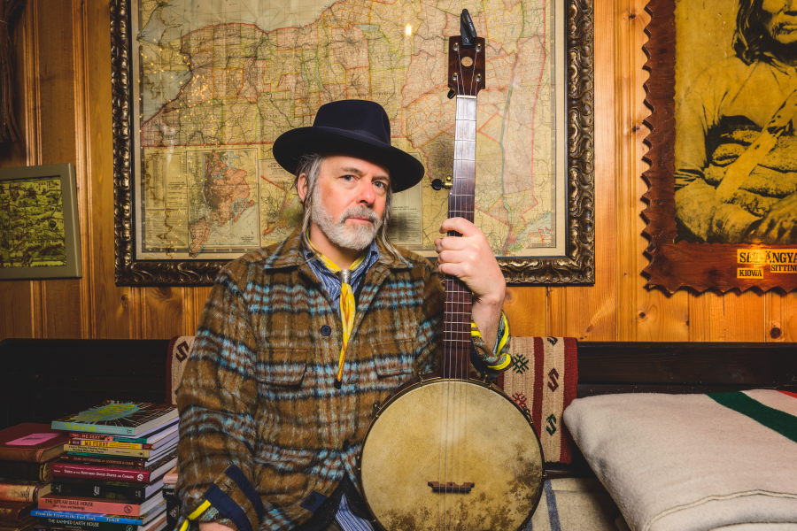Ethan Daniel Davidson poses holding a banjo.
