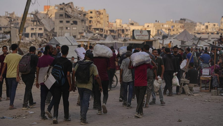 Palestinians carry sacks of food and humanitarian aid unloaded from trucks convoy that had been heading to Gaza City, in the northern Gaza Strip, Sunday, June 22, 2025.