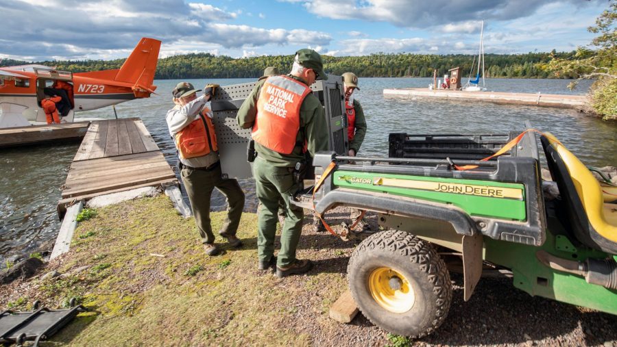 FILE - This Sept. 26, 2018 file photo provided by the National Park Service shows NPS staff unloading a crated gray wolf from a United States Fish & Wildlife Service aircraft at Isle Royale National Park in Michigan.