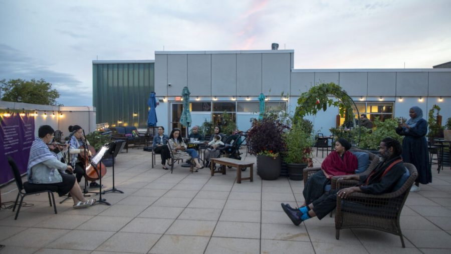 Guests lounge in a rooftop garden while a string quartet plays