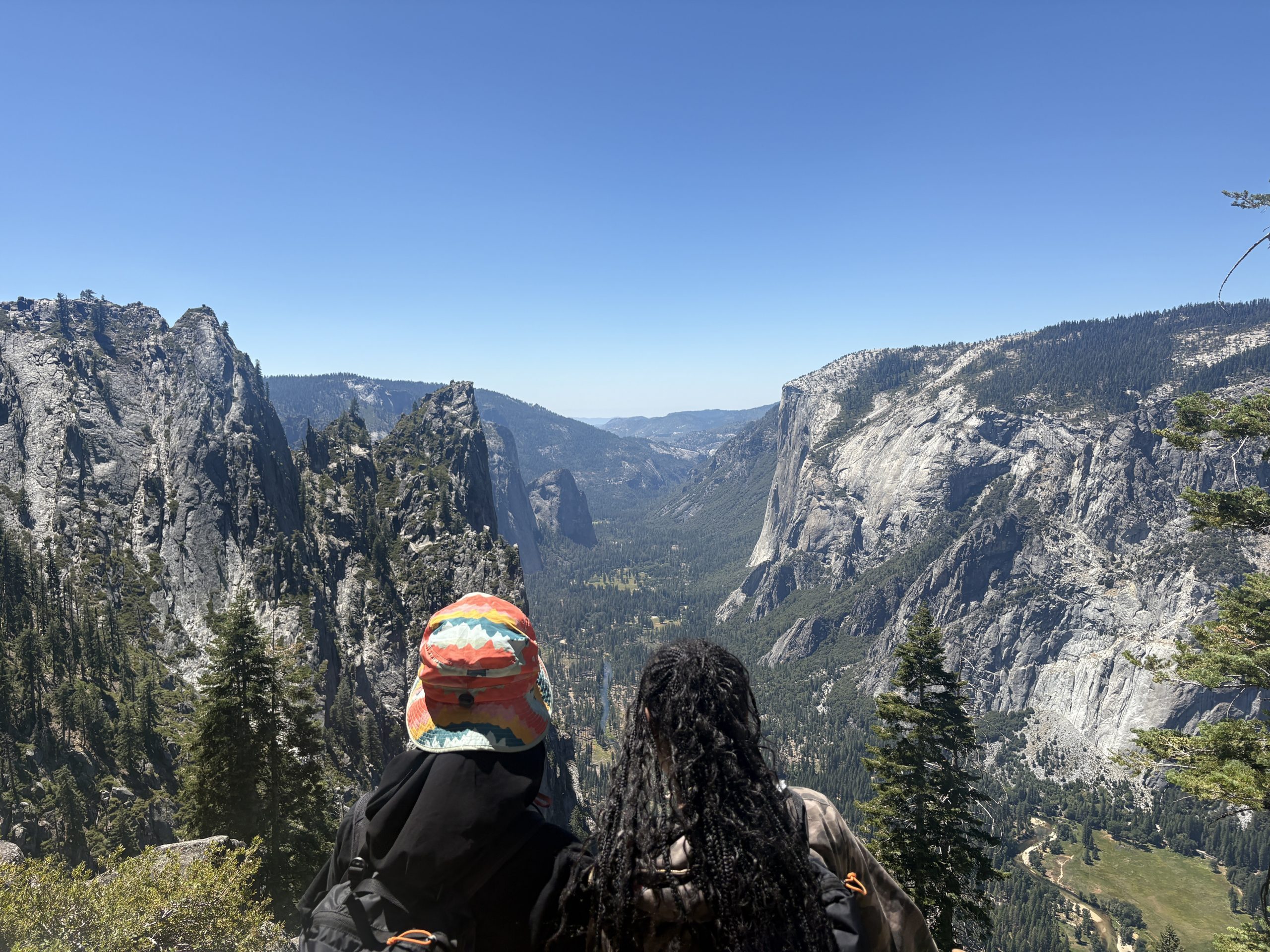 Two students sit at the top of a mountain in Yosemite