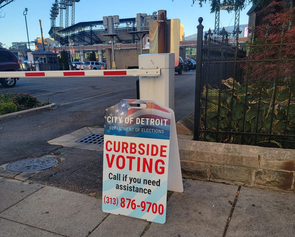 Curbside voting sign in Detroit. Comerica Park in the background.