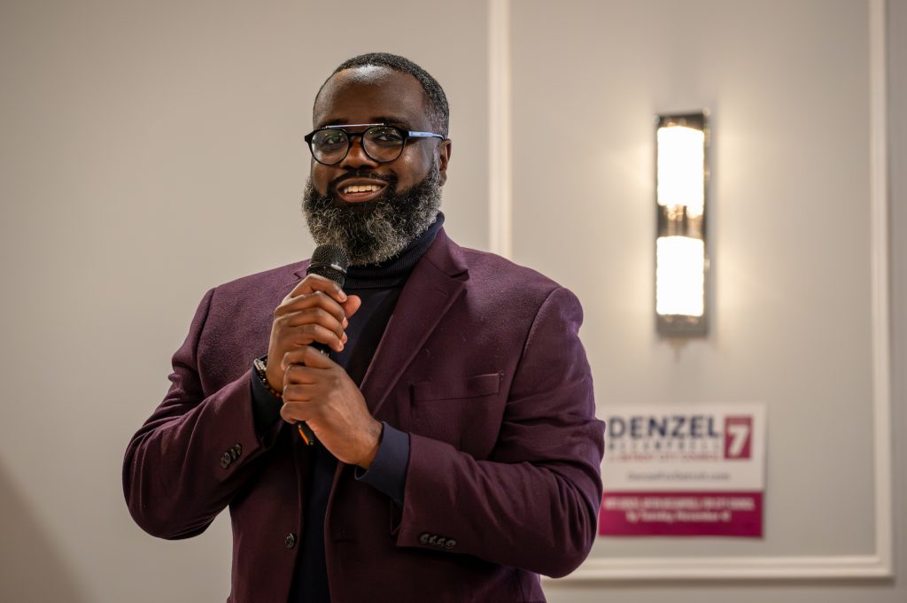 Denzel McCampbell stands with a mic in hand at his election night gathering.