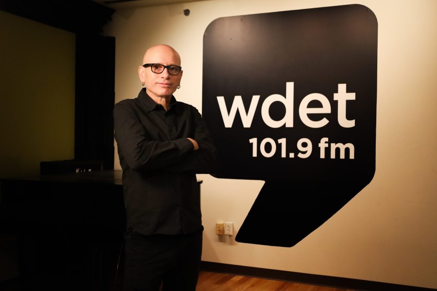 Darren Revell stands in front of a large WDET logo decal.
