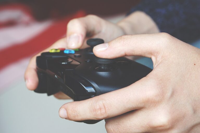 Hands holding X Box controller, mid-movement as the individual plays a video game.