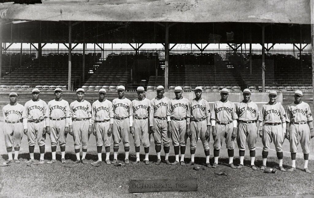 Black baseball players on the Detroit Stars team stand lined up on the field.