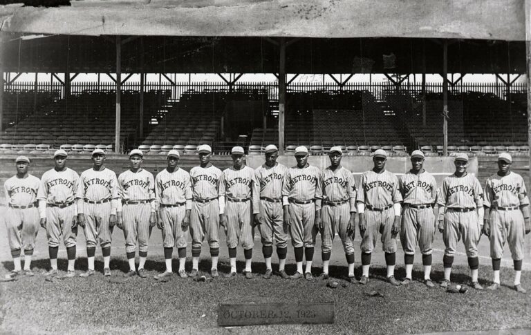 Black baseball players on the Detroit Stars team stand lined up on the field.