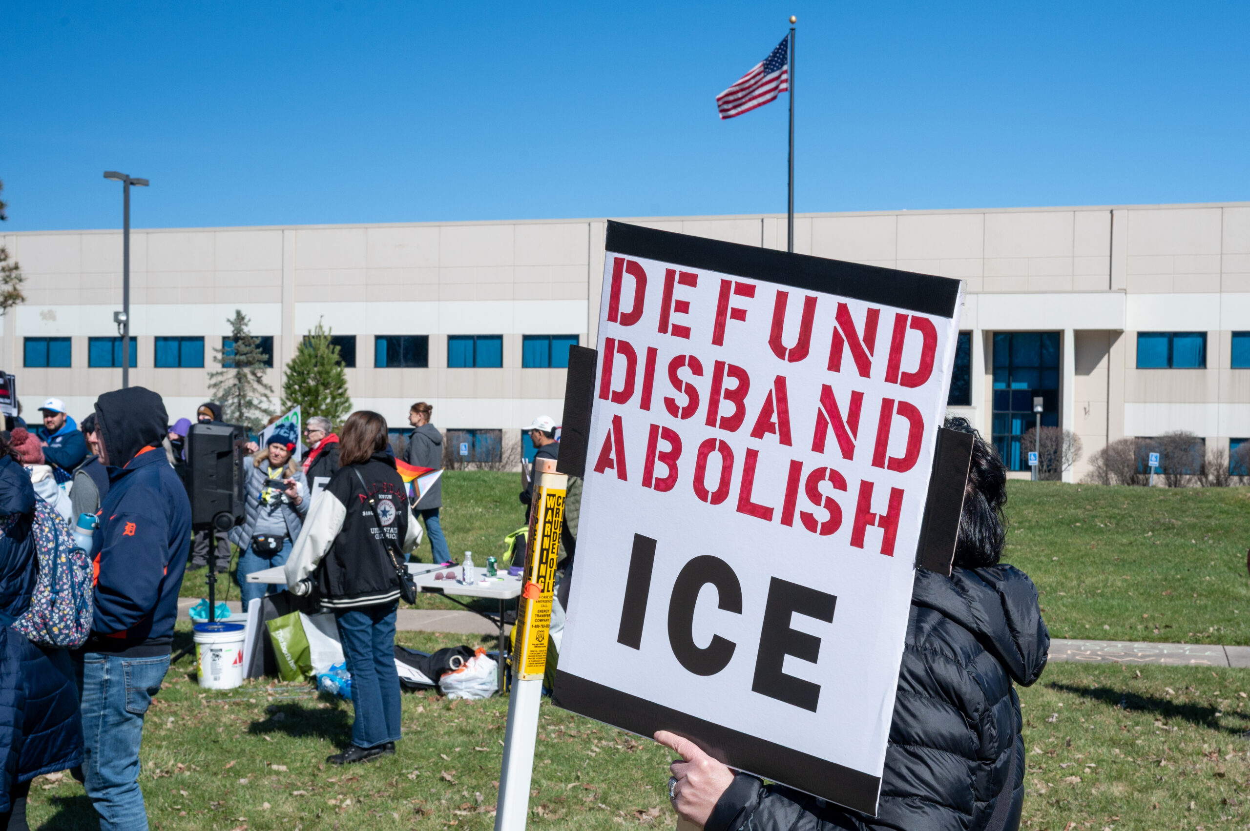 A 'No Kings' protester in front of a warehouse in Romulus that the U.S. Department of Homeland Security wants to turn into a detention center for immigrants.