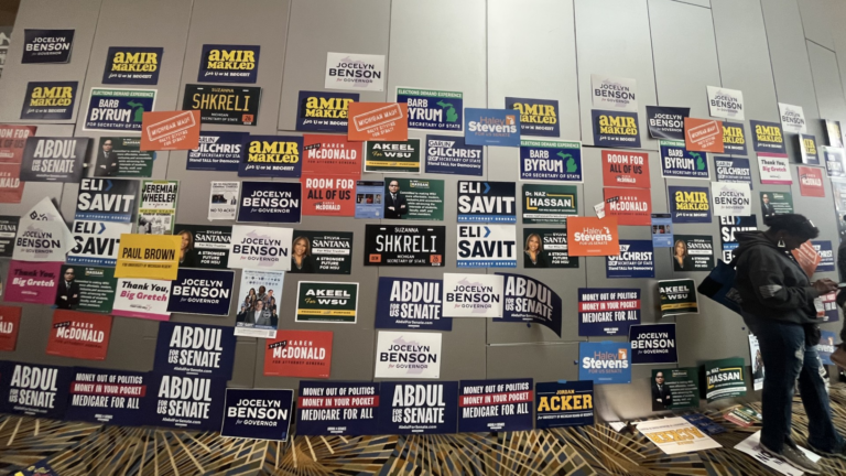 Elections signs are posted on a wall in a ballroom