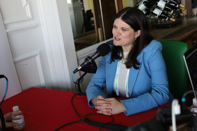 Haley Stevens sits at a table with a microphone in front of her.