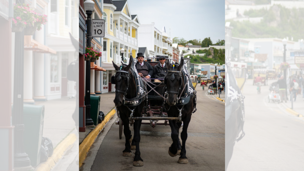 A horse drawn carriage is making its way through Mackinac streets.