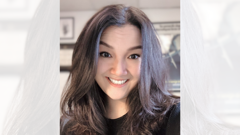 A woman happily smiles at the camera