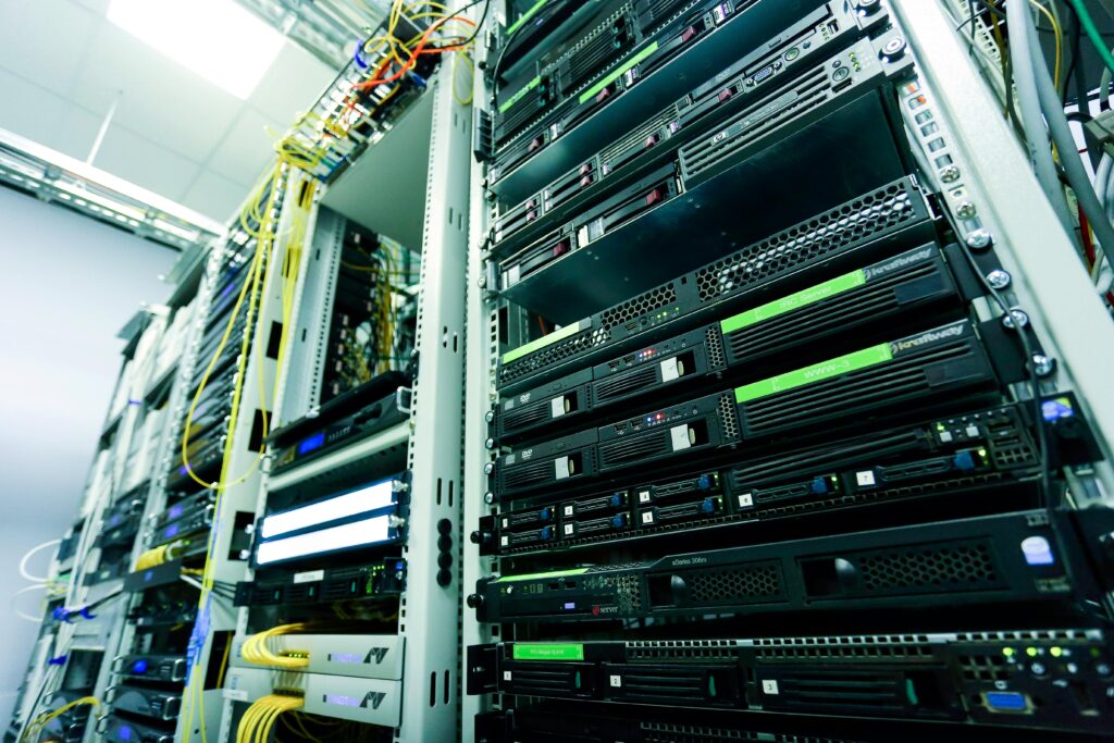 Computer servers stacked in a row underneath bright light.