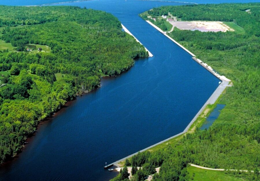 A dark blue waterway cuts through green forested land on either side.