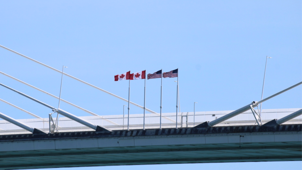 Two Canadian flags and two American flags fly on the bridge.
