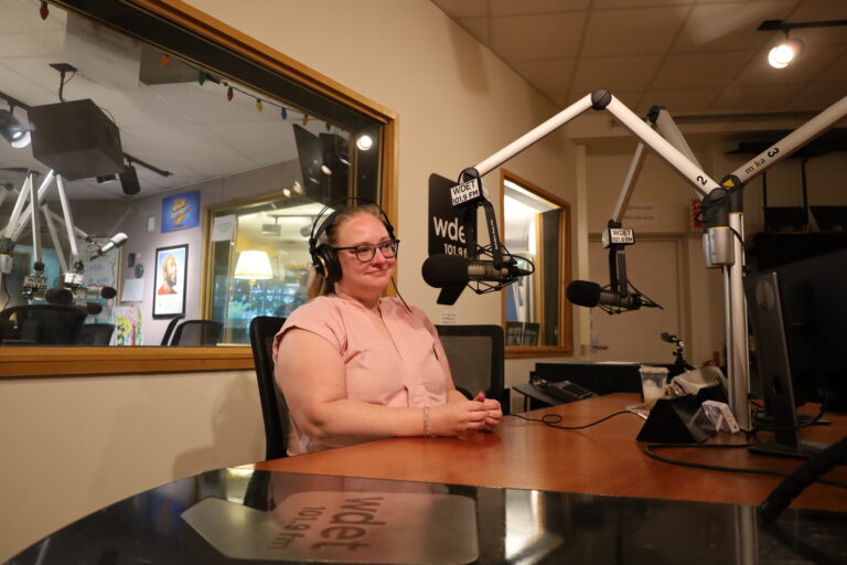 Andrea Bitely sits back in front of a WDET mic.