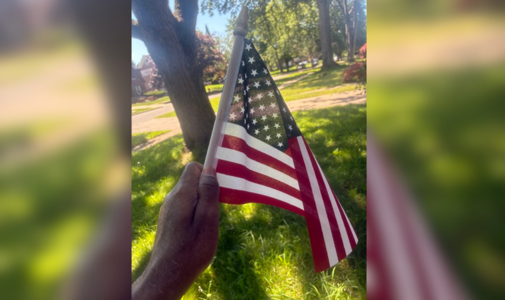 Black hand holds an American flag.