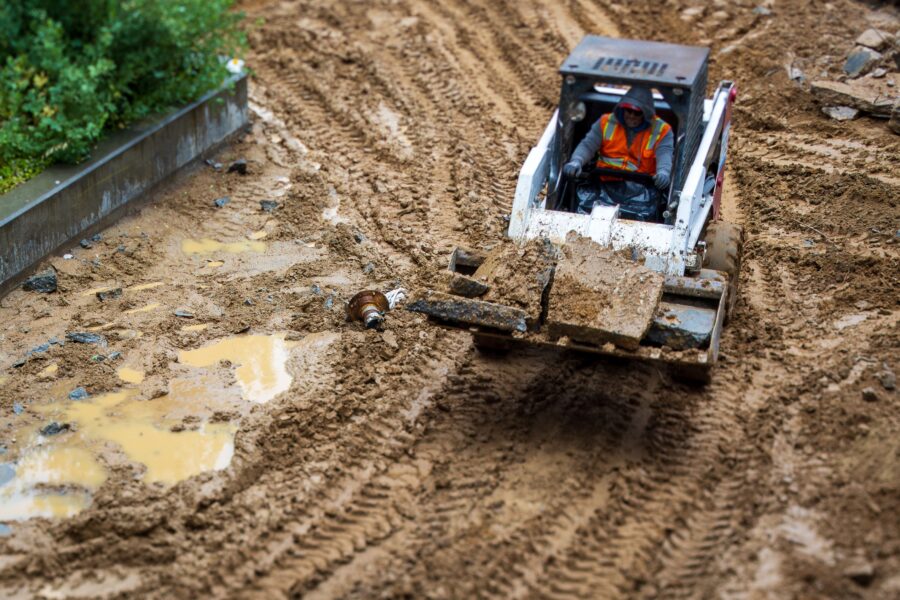 A man moves dirt across a construction site.
